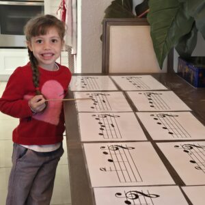 A picture of a little girl pointing at musical notes of the "Songs Puzzle Game" 